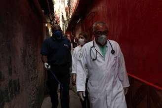 Profissionais de saúde caminham por favela de Paraisópolis, em São Paulo, após moradores terem contratado médicos particulares durante pandemia de coronavírus
30/03/2020
REUTERS/Amanda Perobelli