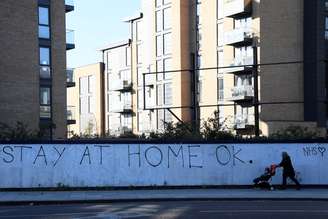 Mulher passa por grafites em uma parede em Brentford, em Londres
01/04/2020
REUTERS/Toby Melville