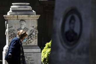 Pedestre com máscara visita cemitério em Roma, capital da Itália