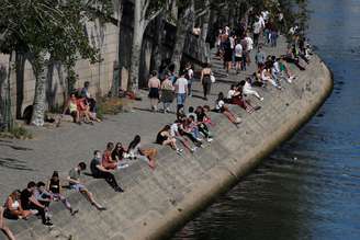 Pessoas se setnam nas margens do Rio Sena, na França, após o país gradualmente relaxar medidas de confinamento pelo coronavírus. 17/5/2020. REUTERS/Gonzalo Fuentes
