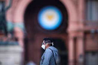 Homem com máscara de proteção em frente à Casa Rosada, sede do governo argentino