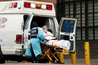 Profissionais da área de sáude transportam paciente para  uma ambulância. 24/04/2020. REUTERS/Lucas Jackson. 

