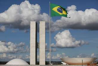 Bandeira do Brasil hasteada na Rua das Bandeiras, em Brasília, tendo, ao fundo, o Congresso Nacional
