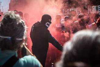 Um grupo de manifestantes pró-democracia, vestidos de pretos e usando máscaras, realiza um ato em frente ao Museu de Arte de São Paulo (Masp)