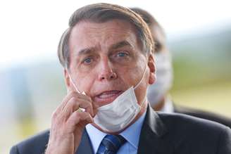 Jair Bolsonaro ajusta máscara ao sair do Palácio do Alvorada, em maio.
REUTERS/Adriano Machado