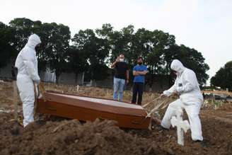 Irmãos Carlos Alexandre e Wagner Cardninot participam de enterro do pai, José Hermínio de Farias, de 76 anos, morto por Covid-19, no Rio de Janeiro.
REUTERS/Pilar Olivares