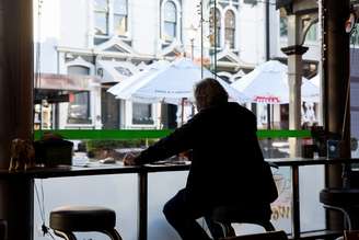 Homem aguarda pedido em café da Nova Zelândia após restrições domésticas serem suspensas
09/06/2020
 REUTERS/Tatsiana Chypsanava