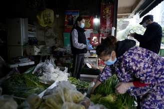 Pessoas com máscara de proteção em mercado de rua em Wuhan, na China
06/04/2020 REUTERS/Aly Song 