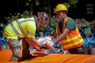 Trabalhadores empilham sacos de areia em torno de uma hidrelétrica enquanto se preparam para a tempestade tropical Isaias em Lower Manhattan em Nova York. 03/08/2020. REUTERS/Brendan McDermid. 
