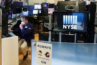 Operador ajusta sua máscara enquanto trabalha no pregão da Bolsa de Valores de Nova York, em 28 de maio de 2020. REUTERS/Lucas Jackson