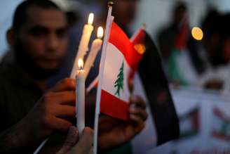 Bandeira libanesa é iluminada com velas. 06/08/2020. REUTERS/Suhaib Salem.

