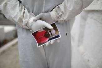 Coveiro segura foto de homem que morreu devido ao coronavírus, durante enterro em cemitério de Nova Iguaçu (RJ)
20/08/2020
REUTERS/Pilar Olivares