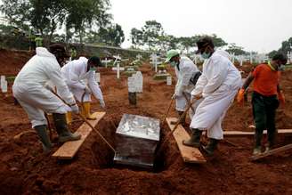 Coveiros trajando roupas de proteção fazem sepultamento em área destinada a vítimas do novo coronavírus em cemitério em Jacarta, Indonésia
24/09/2020
REUTERS/Willy Kurniawan
