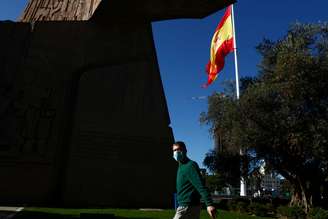 Homem usando máscara caminha perto de bandeira da Espanha em Madri
19/11/2020 REUTERS/Sergio Perez