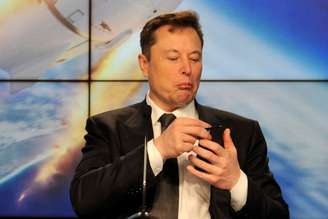Elon Musk observa o smartphone durante conferência
REUTERS/Steve Nesius/