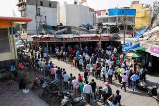 Pessoas fazem fila em frente a loja de bebidas em Nova Délhi depois de governo local decretar seis dias de lockdown para frear disseminação do coronavírus
19/04/2021 REUTERS/Adnan Abidi