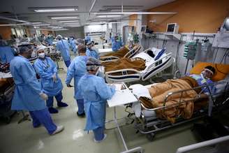 Trabalhadores médicos atendem pacientes do pronto-socorro do hospital Nossa Senhora da Conceição, saturado pelo surto de coronavírus, em Porto Alegre, Brasil.