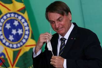 Presidente Jair Bolsonaro mexe na máscara durante cerimônia no Palácio do Planalto
10/06/2021 REUTERS/Adriano Machado