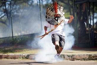 Líder indígena Kretan Kaingang chuta de volta bomba de gás lacrimogêneo lançada pela polícia contra indígenas durante protesto em frente ao Congresso