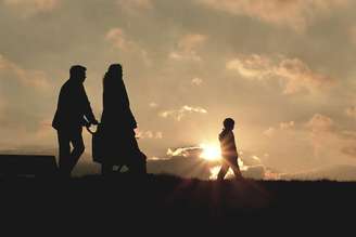Família unida em fé caminhando à tarde em colina - Reprodução/Canva.com