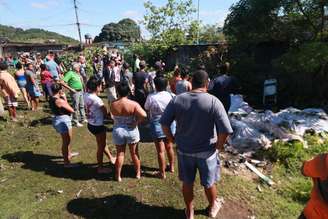 Moradores do Complexo do Salgueiro, em São Gonçalo (RJ), recolhem corpos em uma área de manguezal nesta segunda-feira (22), depois de uma operação da PM na região no último final de semana, com intenso tiroteio entre a polícia e traficantes