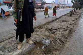 Membro do Talibã segurando uma metralhadora