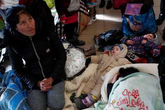 Criança dorme em chão de trem com refugiados ucranianos que tentam chegar até a Hungria