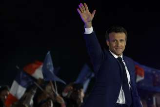 O presidente francês Emmanuel Macron acena ao chegar para fazer um discurso após ser reeleito como presidente