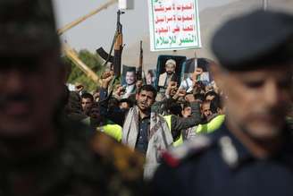 Um apoiador houthi carrega uma arma durante um protesto contra os EUA e a Arábia Saudita pedindo o fim da guerra no Iêmen.