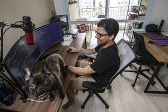 Johnathan Alves no home office montado na sala do apartamento. Para ele, o modelo traz flexibilidade para o seu estilo de vida.