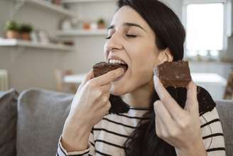 Imagem meramente ilustrativa de uma mulher comendo chocolate