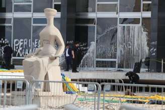 Sede do Supremo Tribunal Federal (STF) depredada após ataque de radicais; à frente, a escultura 'A Justiça' pichada com a frase 'perdeu, mané' - 8/1/2023.