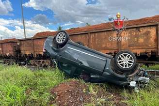 Carro capota após colidir com trem