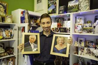 O advogado Sávio Valei posa com as fotos do rei Charles III e da rainha consorte Camilla Parker-Bowles