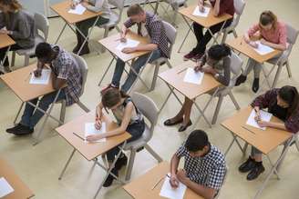 Alunos realizando vestibular em uma sala de aula. 