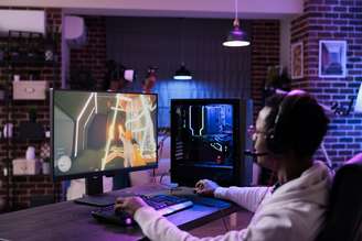 jogador masculino jogando competição de videogame online na estação de computador desfrutando do jogo multiplayer de torneio de e-sport ao vivo campeonato de jogabilidade de streaming