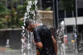 Sol, calor e baixa umidade em São Paulo, nesta sexta feira (17). Na foto pessoas se refrescando em fontes de água no Vale do Anhangabaú.