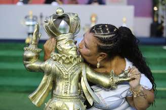 Solange Cruz Bichara, presidente da escola de samba Mocidade Alegre, beija troféu.