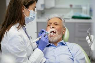 Homem idoso é avaliado por dentista