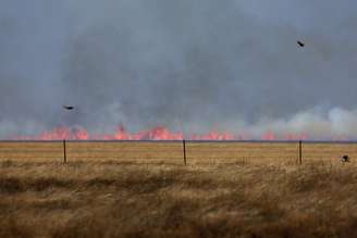 Incêndio florestal pode ser visto, levemente desfocado pelas ondas de calor, depois de ter sido fustigado por ventos fortes em Pampa, Texas 02/03/2024
