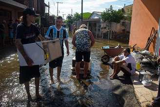 Moradores do Quilombo dos Machado e da Vila Respeito tentar salvar o que sobrou em uma das áreas mais afetadas de Porto Alegre