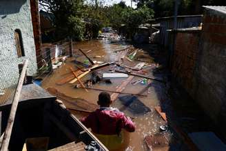 Na foto, Valderci Trindade, 24, que perdeu a própria casa, tenta salvar itens úteis na enchente em Serraria, Porto Alegre, Rio Grande do Sul. (14/05/2024)