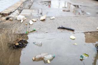 Lixo flutua na superfície da água após chuva forte e inundação