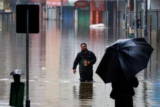 Um homem anda por uma rua com enchente em Porto Alegre, Rio Grande do Sul 