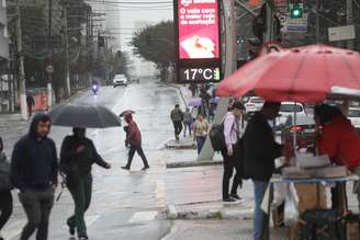 Pedestres enfrentam chuva e frio, com termômetros oscilando entre 16°C e 17°C graus, na manhã desta terça-feira (30/7), próximo à Estação de metrô do Brooklin, na zona sul de São Paulo.