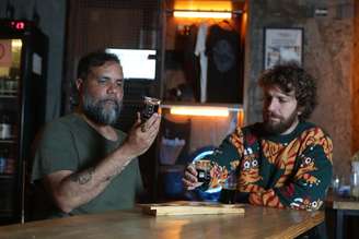 Os sócios Humberto Ribeiro e Pedro Henrique Butelli provam as novas cervejas envelhecidas em barril de bourbon da Hocus Pocus. FOTO ALEX SILVA/ESTADÃO