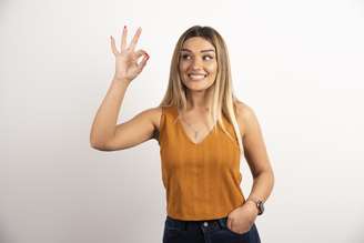 Mulher fazendo teste do olho dominante com a técnica do buraco nas mãos.