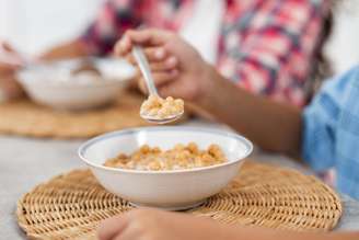 Crianças comendo cereais no café da manhã.