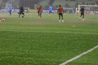 Jogadores aquecem em maio à chuva antes de clássico