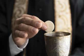 Padre segurando a eucaristia